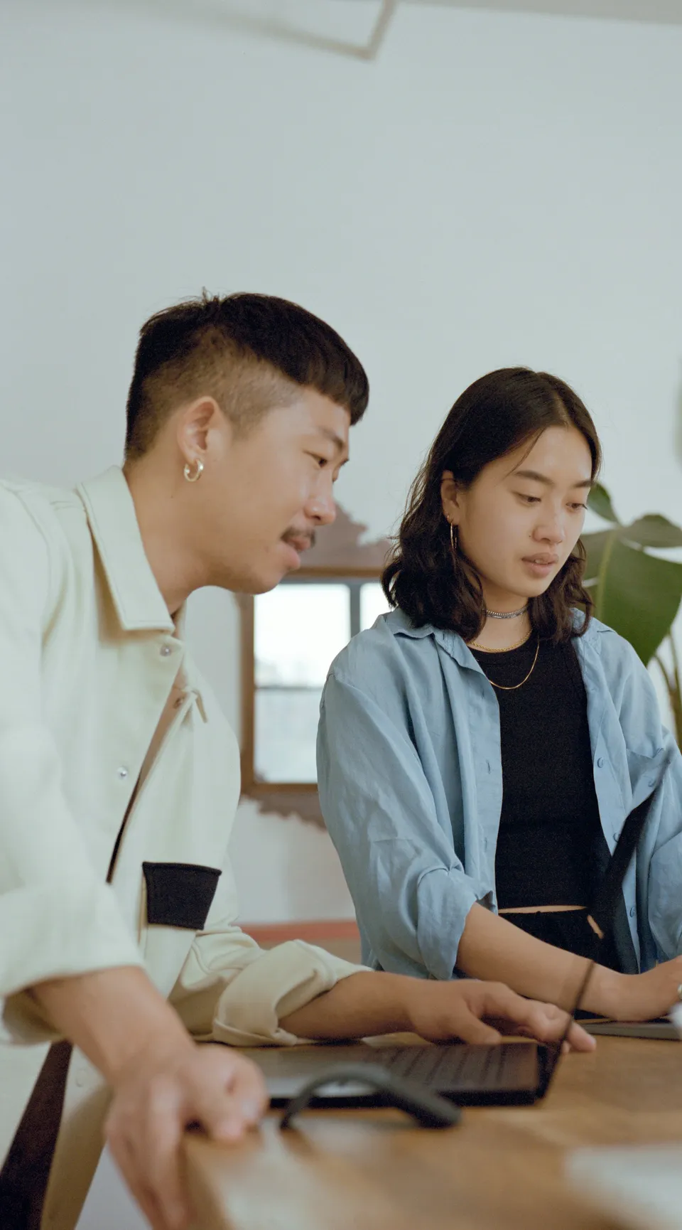 Two colleagues reviewing a project together on a laptop
