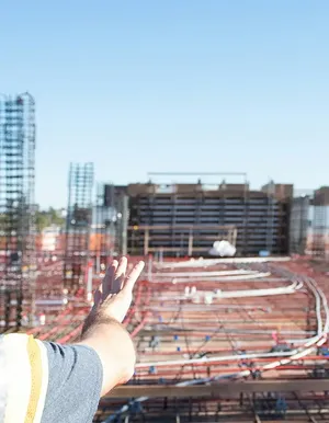 Hand pointing across a construction site