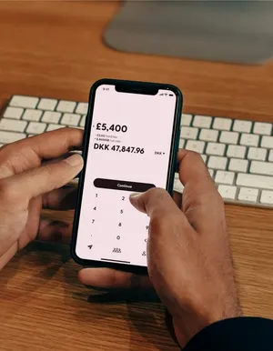Hands holding a phone with a banking app balance